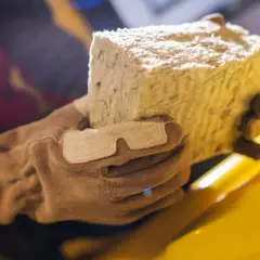 Rękawica trzyma blok wełny skalnej, materiału izolacyjnego.