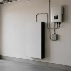 Biały magazyn energii i falownik na ścianie garażu. System zapewnia niezależność energetyczną.