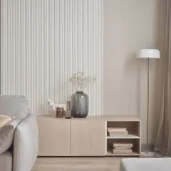 Nowoczesna ściana z ryflowaniem, komoda z książkami i wazonem, obok sofa. Idealne co na ścianę do salonu.