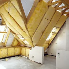 Ocieplenie stropu w trakcie prac. Widoczne drewniane konstrukcje i żółta wełna mineralna.