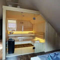 Nowoczesna sauna w domu, z przeszklonymi drzwiami i nastrojowym oświetleniem, idealna do relaksu.