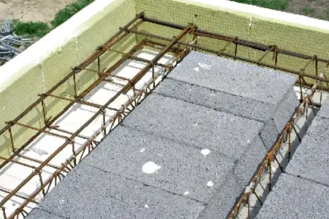 Budowa stropu: betonowe pustaki i zbrojenie tworzą solidny wieniec stropowy, otoczony izolacją.